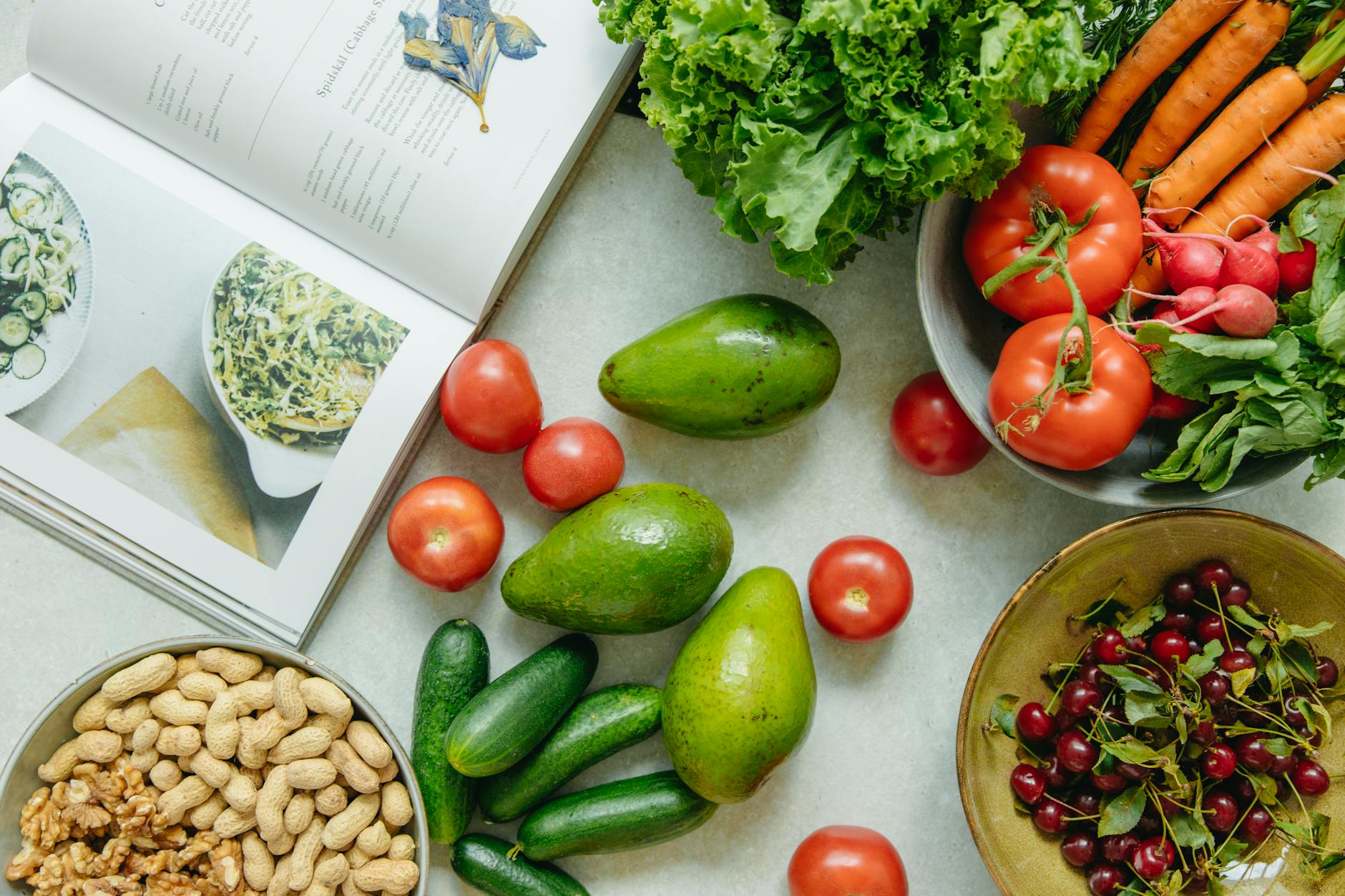 top view of a cookbook and variety of healthy foods on a table